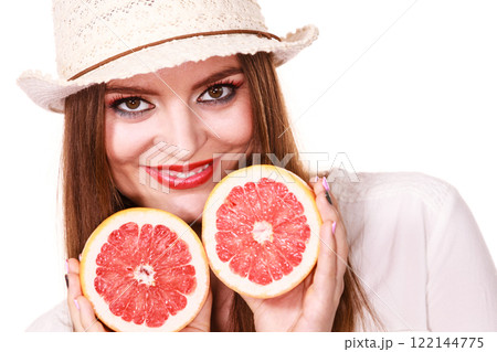 Woman holds two halfs of grapefruit citrus fruit in hands 122144775