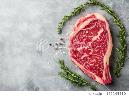 Raw wagyu rib eye steak with rosemary and pepper on kitchen table top.Macro.AI Generative. 122145510