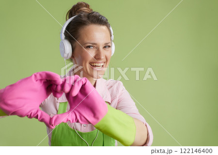 happy 40 years old woman showing heart hands isolated on green 122146400