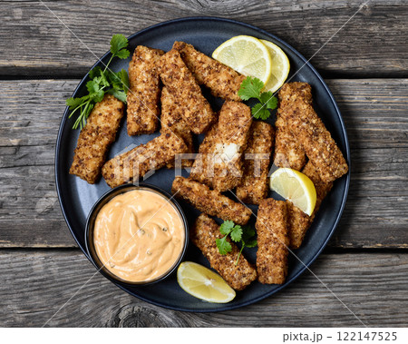 pretzel crusted fish sticks with lemon, mayo sauce 122147525