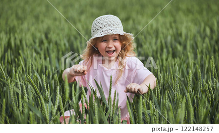 Cute little girl with blond hair and straw hat having fun in a wheat field, enjoying a sunny summer day Cute little girl with blond hair and straw hat having fun in a wheat field, enjoying a sunny summer day 122148257