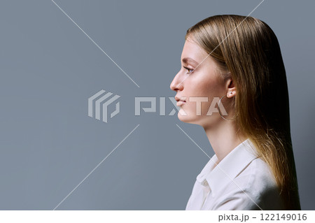 Profile view, serious young woman, copy space gray studio background 122149016