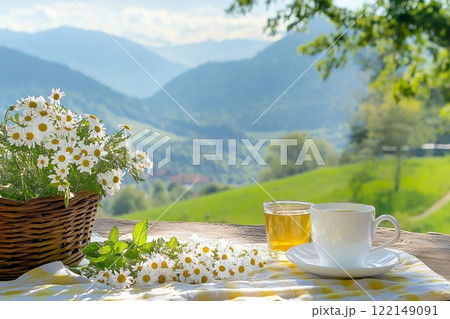 Cup of Tea and Chamomile Flowers on Wooden Table Overlooking Mountains. Peaceful Scene with Bright Daylight and Green Hills. Ideal for Relaxation or Herbal Tea Themes. AI generated 122149091