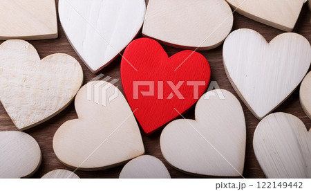 Red Wooden Heart Among White Hearts on Wooden Background 122149442