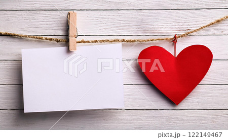 Blank White Card and Red Heart Hanging on Rope with Wooden Background 122149467