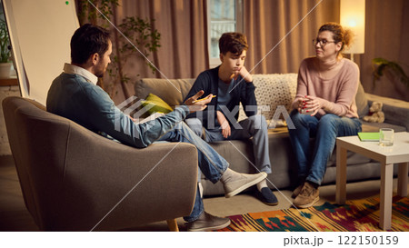 Man, psychologist talks with mother and her teenage son, discuss family problems to improve their relationship and solve issues. Open communication. 122150159