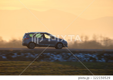 Car driving fast on intercity road at sunset. Highway traffic in evening 122150529