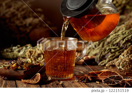 Hot herbal tea is poured into a glass mug. Hot herbal tea is poured into a glass mug. 122151519