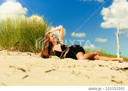 Woman sunbathing on beach. 122152101