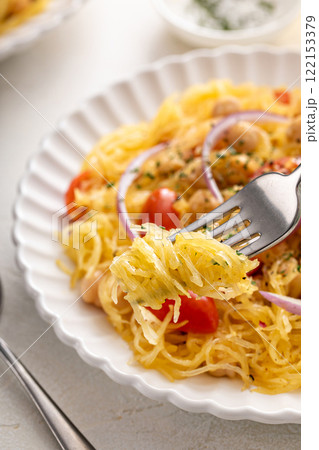 Spaghetti squash with chickpeas and tomatoes topped with red onion, low carb vegan recipe idea 122153379