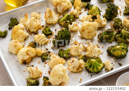 Broccoli and cauliflower roasted on a baking sheet with herbs 122153402