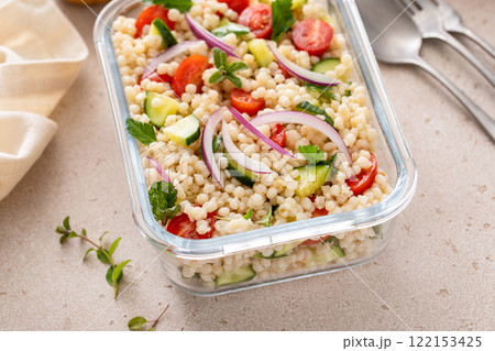 Pearl couscous salad with fresh vegetables and red onion in a meal prep container Pearl couscous salad with fresh vegetables and red onion in a meal prep container 122153425