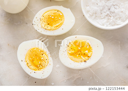 Soft boiled eggs cut in half with salt and pepper Soft boiled eggs cut in half with salt and pepper 122153444