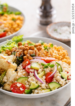 Vegan lunch bowl with lentils, roasted vegetables and chickpeas, pearl couscous salad Vegan lunch bowl with lentils, roasted vegetables and chickpeas, pearl couscous salad 122153454