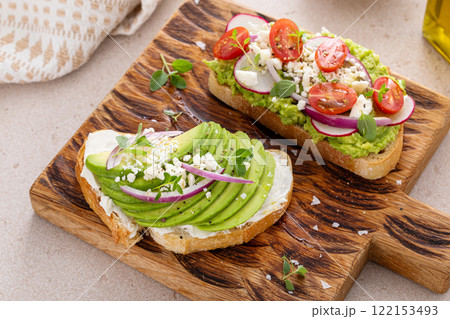 Fresh avocado toasts on wooden board 122153493