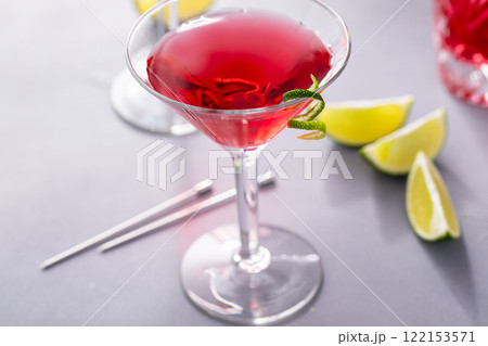 Martini cocktail with cranberry juice garnished with lime twist 122153571