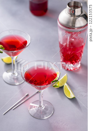 Martini cocktail with cranberry juice garnished with lime twist 122153575