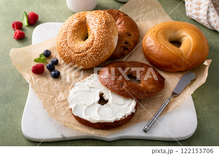 Freshly baked bagels ready to eat for breakfast, sesame, cinnamon and plain with cream cheese 122153706