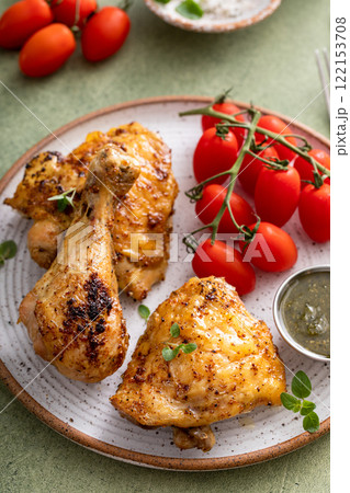 Roasted chicken drumsticks and thighs with pesto and tomatoes Roasted chicken drumsticks and thighs with pesto and tomatoes 122153708