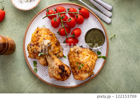Roasted chicken drumsticks and thighs with pesto and tomatoes Roasted chicken drumsticks and thighs with pesto and tomatoes 122153709