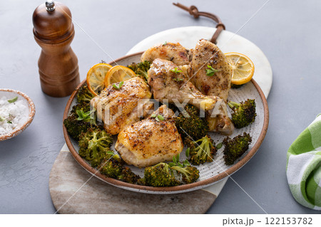 Chicken drumsticks and thighs with broccoli roasted on a serving plate for dinner or lunch 122153782