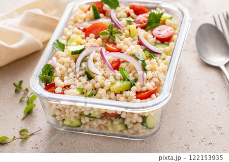 Pearl couscous salad with fresh vegetables and herbs in a meal prep container, healthy lunch or side dish Pearl couscous salad with fresh vegetables and herbs in a meal prep container, healthy lunch or side dish 122153935