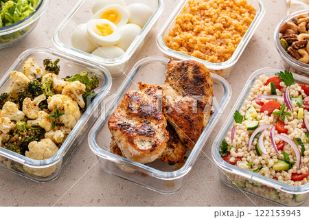 Healthy meal prep with cooked chicken breast, boiled eggs, roasted vegetables, cooked lentils, couscous salad and nuts 122153943