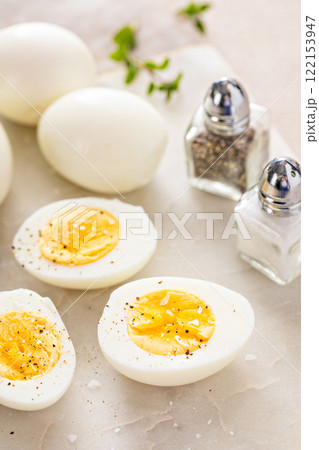 Boiled eggs peeled and cut in half with salt and pepper 122153947