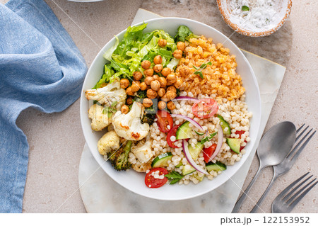 Vegan lunch bowl with roasted vegetables, fresh lettuce, cooked lentils, couscous salad and roasted chickpeas 122153952