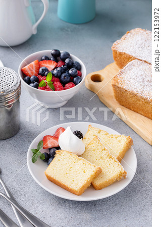 Traditional vanilla pound cake sliced and served with whipped cream and berries Traditional vanilla pound cake sliced and served with whipped cream and berries 122153972