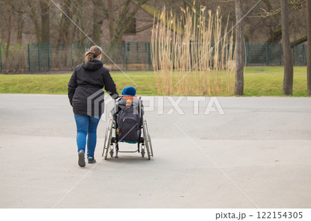 Woman, child disability love Disabled, cerebral palsy boy in wheelchair. Woman, child disability love Disabled, cerebral palsy boy in wheelchair. 122154305