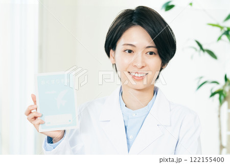 笑顔でお薬手帳を持つ女性薬剤師 笑顔でお薬手帳を持つ女性薬剤師 122155400