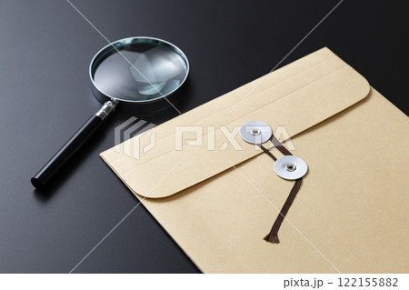 黒背景に虫眼鏡と紐付き封筒 122155882