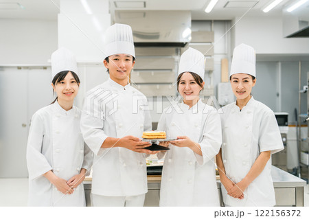 厨房・キッチンに立つコックコート姿の調理師・シェフ・コックの男女 厨房・キッチンに立つコックコート姿の調理師・シェフ・コックの男女 122156372