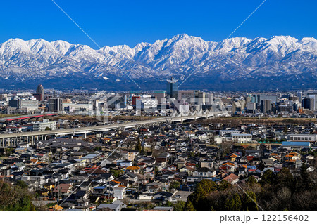 呉羽山から眺めた富山市街地と雪の立山連峰 122156402