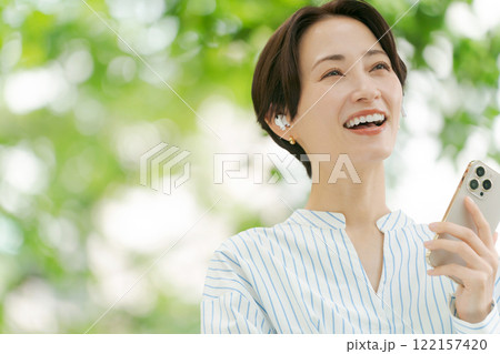 新緑の中で音楽を聴く女性 122157420