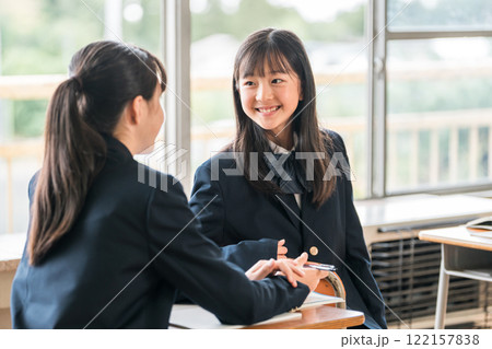学校の教室で会話する中学生の女子生徒 122157838