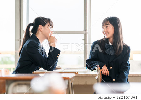 学校の教室で会話する中学生の女子生徒 122157841