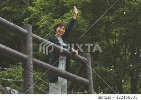 新緑に覆われた山と若い女性 122158335