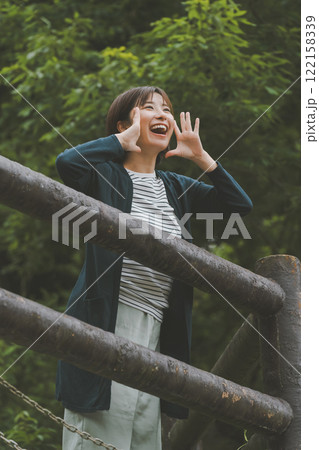 新緑に覆われた山と若い女性 新緑に覆われた山と若い女性 122158339