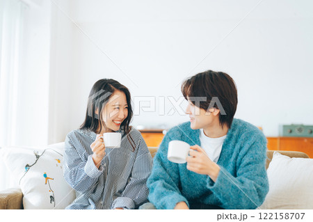 コーヒーを飲みながら笑顔で会話する若いカップル 122158707