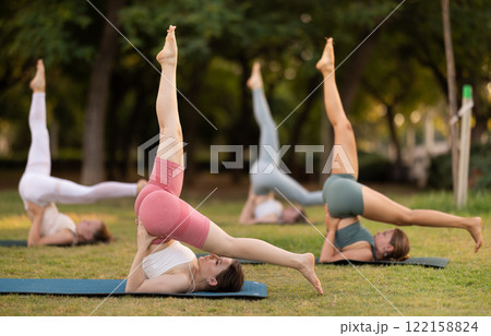 Group of young women doing yoga in park 122158824