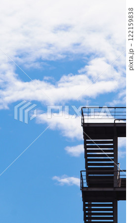 Open Sky Ladder. A minimalist image showcasing a staircase against a vivid blue sky with scattered clouds, symbolizing ascension and limitless possibilities Open Sky Ladder. A minimalist image showcasing a staircase against a vivid blue sky with scattered clouds, symbolizing ascension and limitless possibilities 122159838