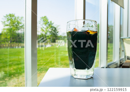 キレイな風景が見えるカフェ。氷が入ったアイスコーヒー。 キレイな風景が見えるカフェ。氷が入ったアイスコーヒー。 122159915