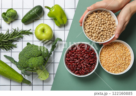 Set of vegetarian protein products and female hands on green and white background, top view 122160885