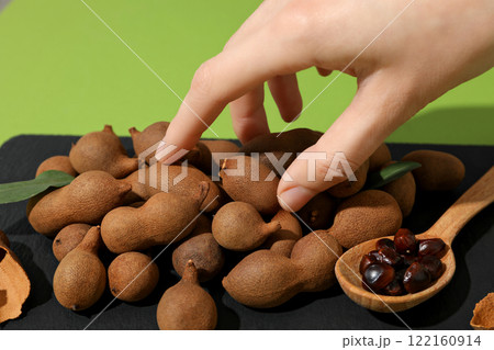 Ripe tamarind on a black plate on a green background 122160914