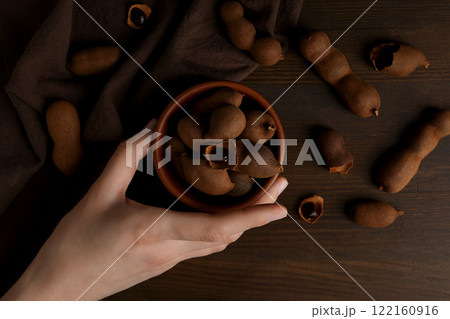 Ripe tamarind in a bowl on a wooden background Ripe tamarind in a bowl on a wooden background 122160916