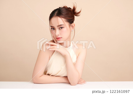 Beautiful young asian woman with clean fresh skin on beige background, Face care, Facial treatment, Cosmetology, beauty and spa, Asian women portrait. Beautiful young asian woman with clean fresh skin on beige background, Face care, Facial treatment, Cosmetology, beauty and spa, Asian women portrait. 122161097