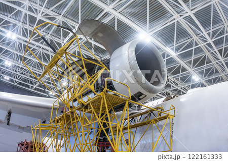 Open high-bypass turbofan aircraft engine of a transport airplane in a hangar 122161333