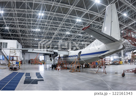 Transport turboprop airplane in the hangar. Aircraft under maintenance. Checking mechanical systems for flight operations 122161343